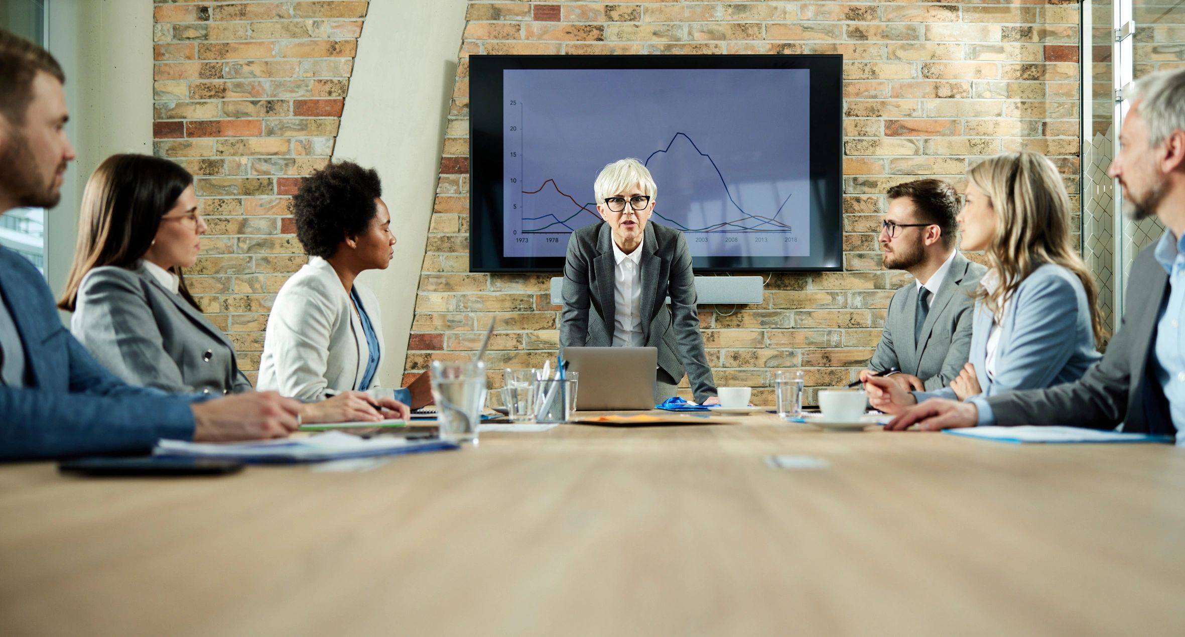 Senior executive leading an editorial-style strategy meeting
