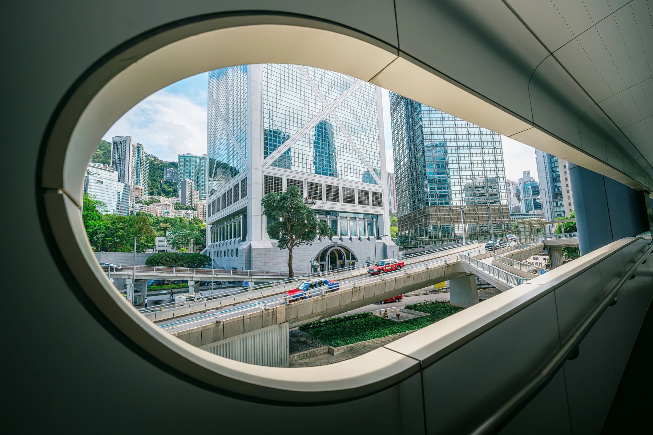Hong Kong Central skyline framed from a pedestrian walkway with elevated escalator-style urban circulation