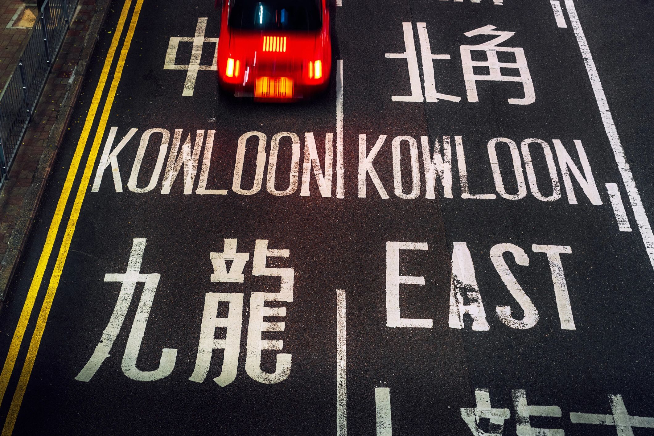 Night street scene in Kowloon with Hong Kong taxi and bold road markings